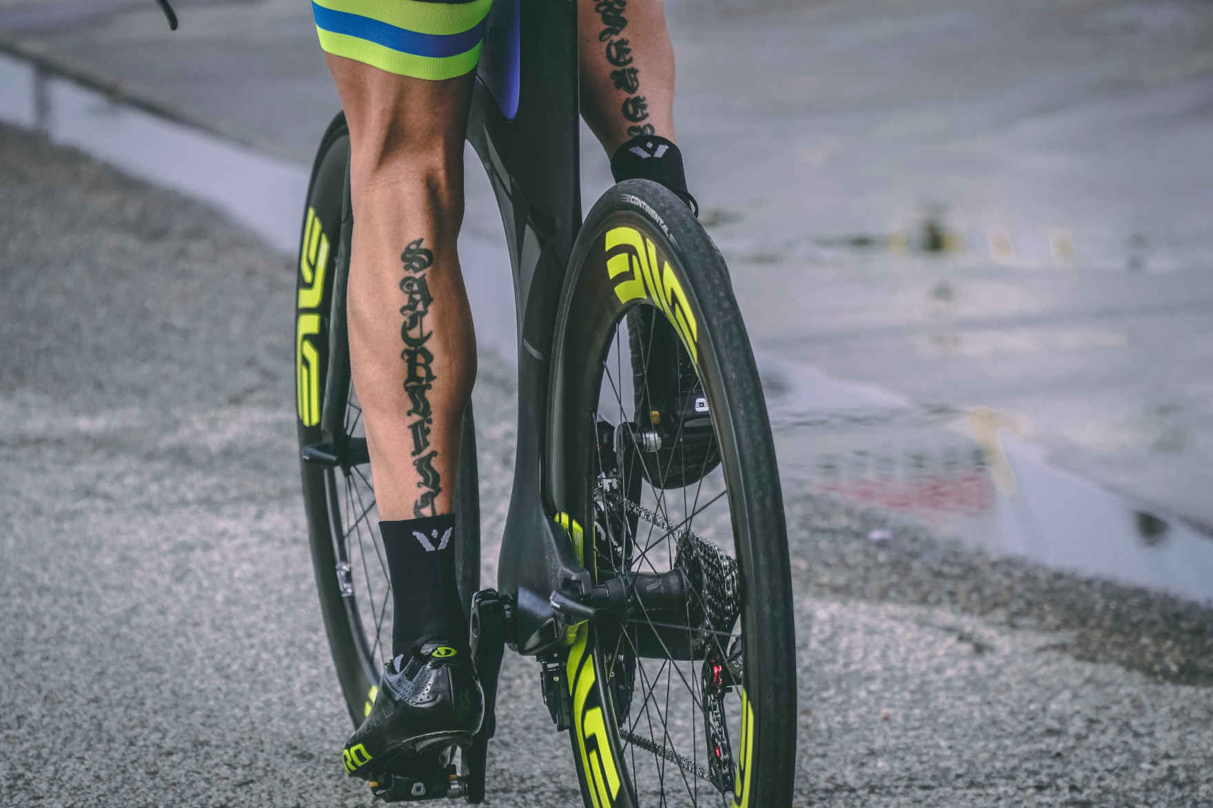 The back of a cyclists legs as he pedals