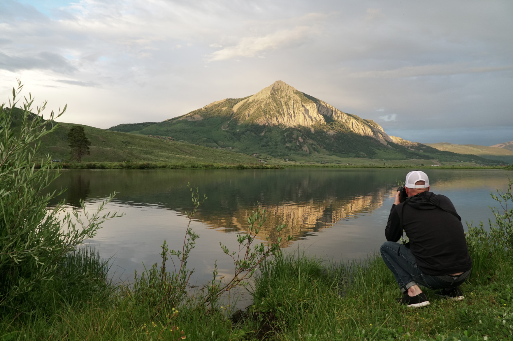 Photographer with mountain and lake in background