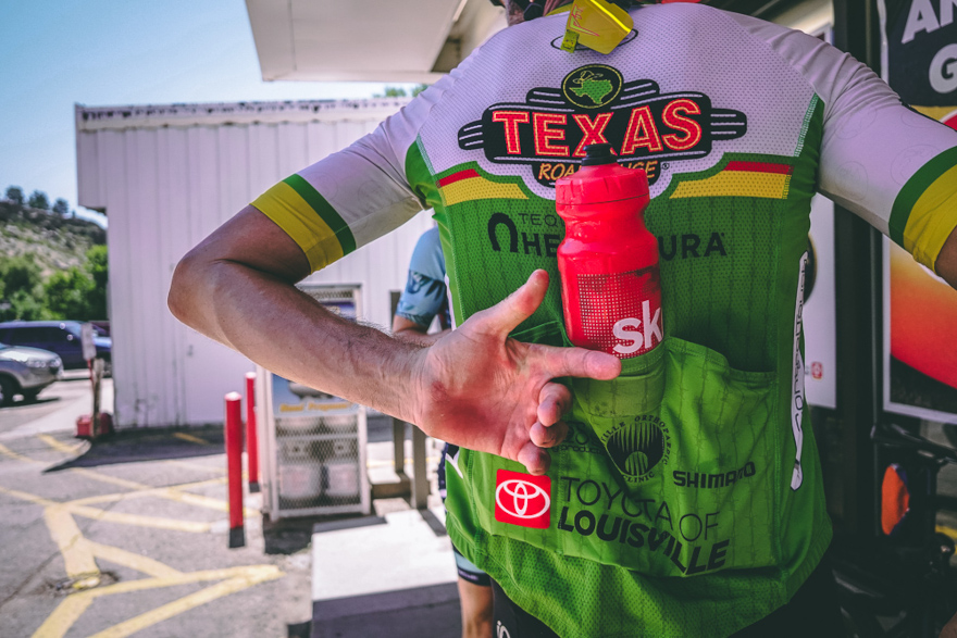 Man grabbing water bottle from cycling jersey pocket