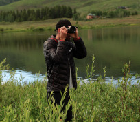 Andrew taking a picture in the tall grass